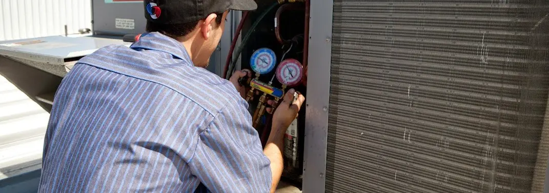 HVAC technician servicing a condenser unit in Offutt AFB